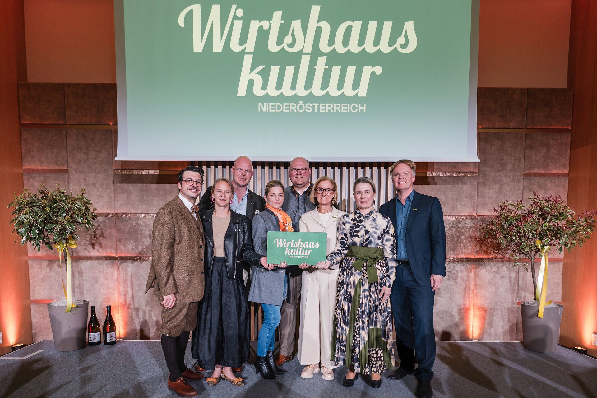 Gruppenfoto beim Fest der Wirtshauskultur Niederösterreich 2026 im Congress Center Luberegg. Acht Personen stehen vor einer Leinwand mit dem Logo „Wirtshauskultur Niederösterreich“; mehrere von ihnen halten gemeinsam ein Schild mit dem Wirtshauskultur-Logo.