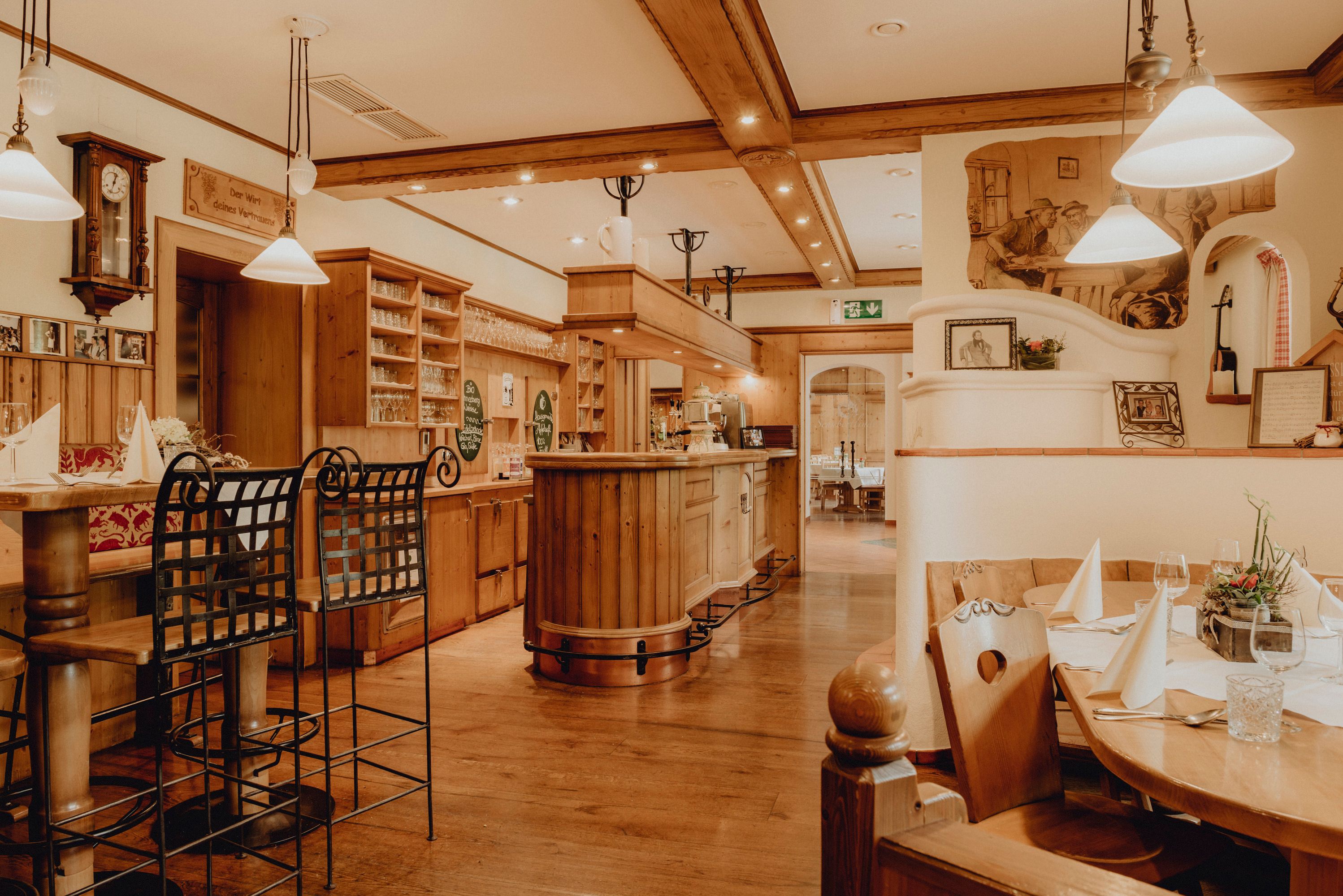 Gemütliches Restaurant mit Holzmöbeln, Bar und gedeckten Tischen.