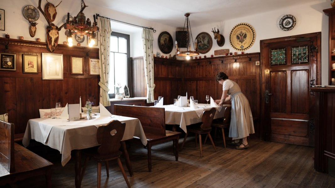 Traditionelles Wirtshaus mit Holzvertäfelung und Jagdtrophäen an den Wänden.