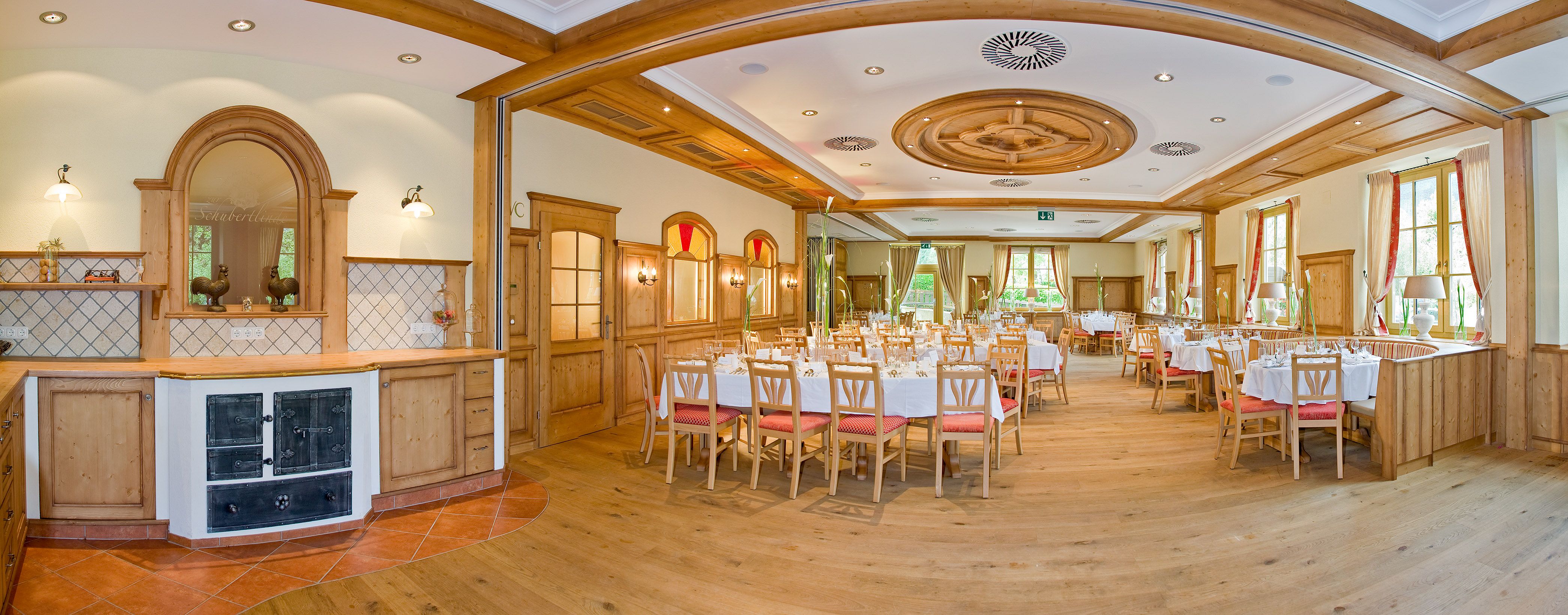 Eleganter, holzverkleideter Speisesaal mit gedeckten Tischen und großen Fenstern.