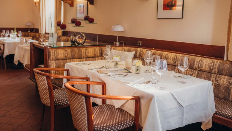 Elegantes Restaurant mit gedecktem Tisch, wei&szlig;en Tischdecken und stilvollen St&uuml;hlen.