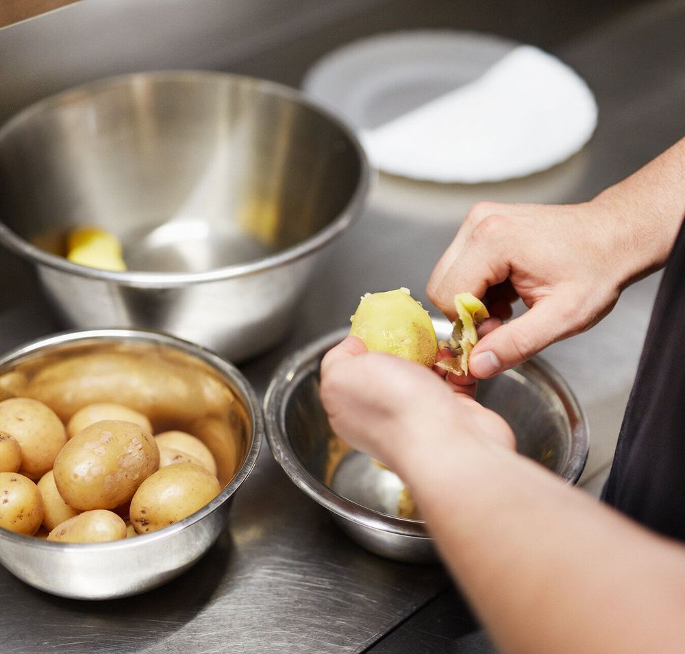 In einer einladenden Küche werden frische Erdäpfel sorgfältig geschält, bereit für die Zubereitung köstlicher Spezialitäten. Der Duft von frisch gekochten Erdäpfelknödeln erfüllt den Raum und verspricht ein unvergessliches Geschmackserlebnis. Hier wird die Tradition der österreichischen Küche mit Liebe und Hingabe gelebt.