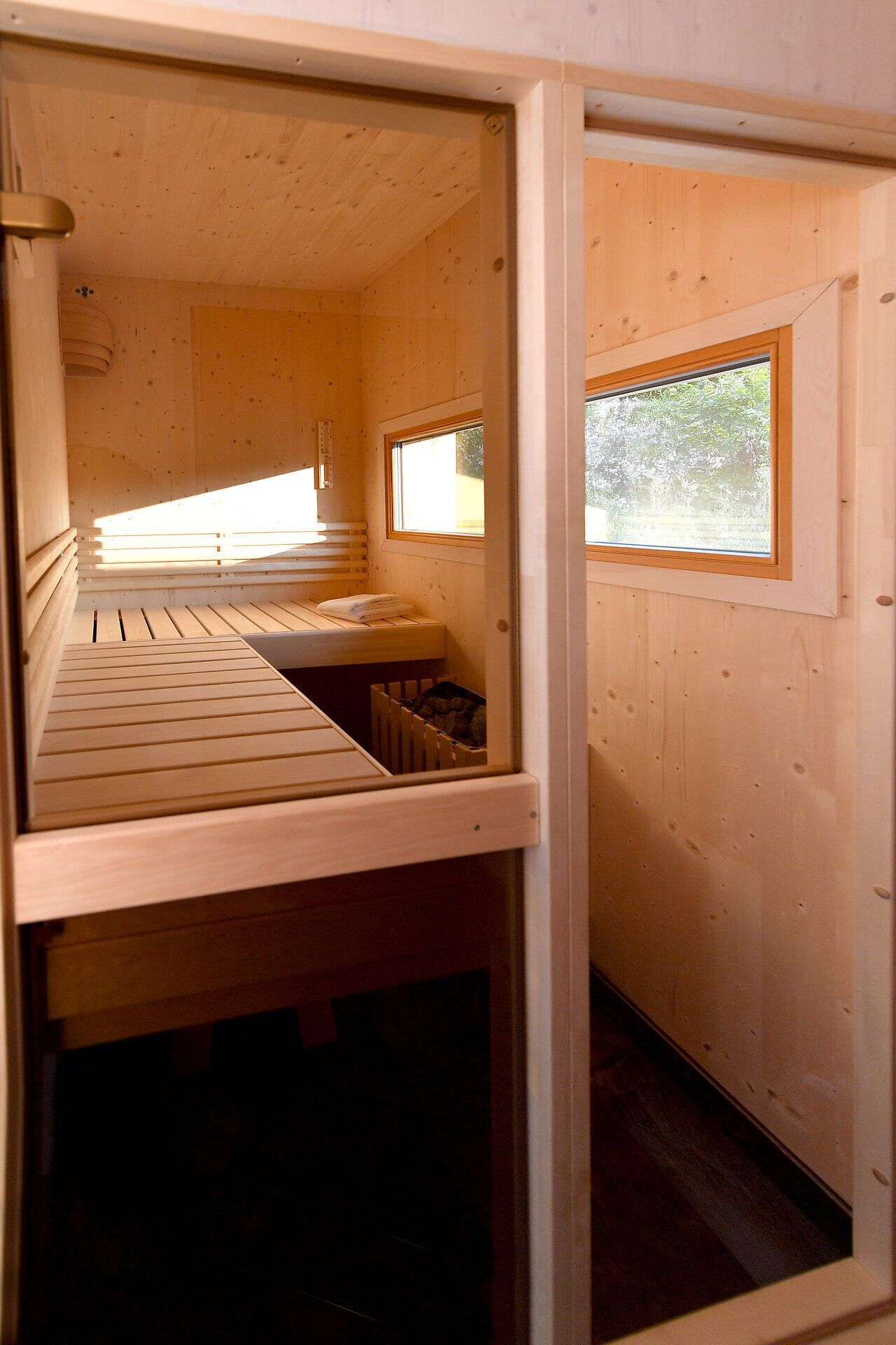 In dieser gemütlichen Sauna aus Holz, umgeben von warmem Licht und der beruhigenden Atmosphäre des Waldes, können Besucher die Seele baumeln lassen. Der Duft von frischem Holz und die sanfte Wärme laden dazu ein, den Alltagsstress hinter sich zu lassen und die Ruhe der Natur zu genießen.