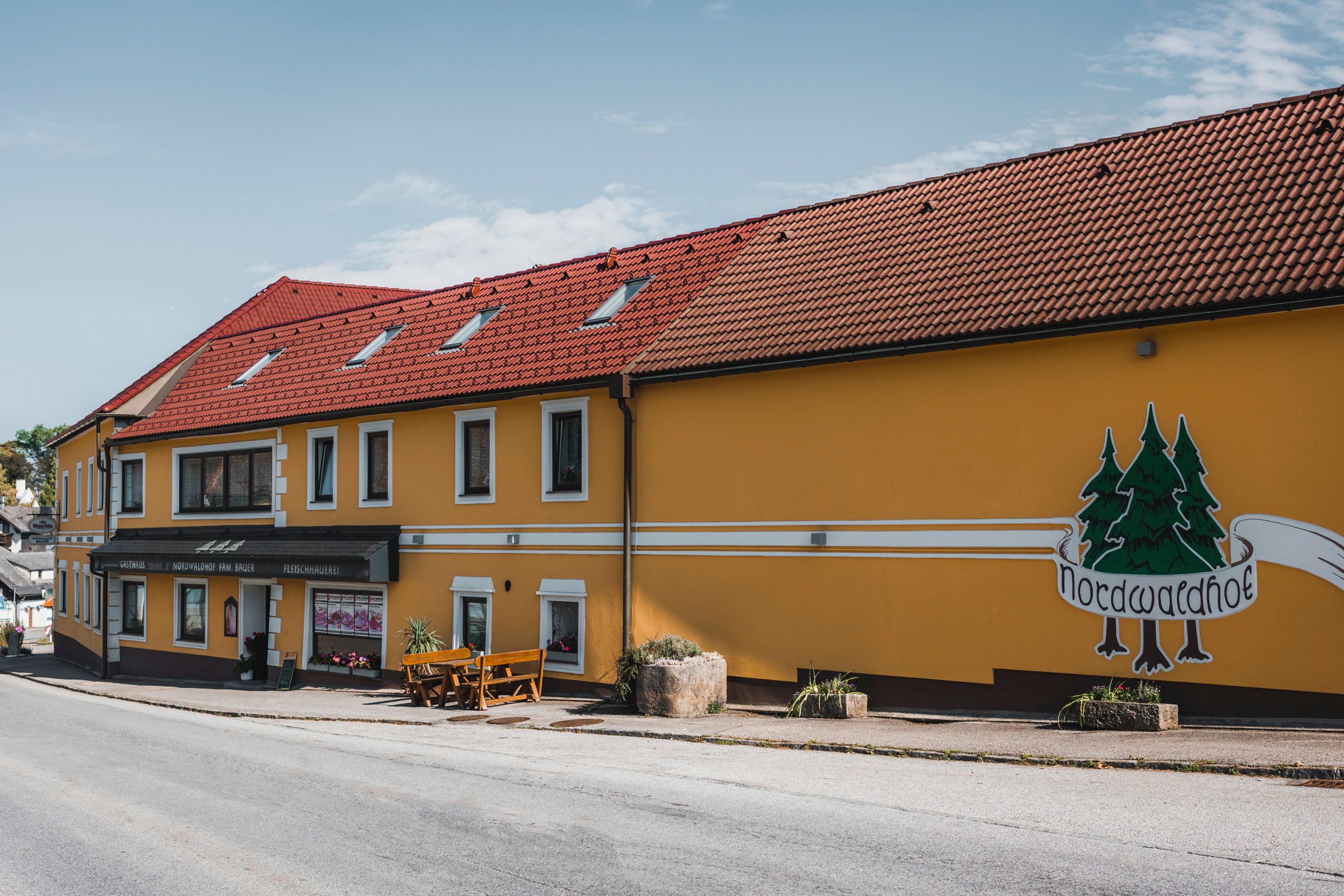 Gelbes Gebäude mit rotem Dach und Aufschrift 'Nordwaldhof'.