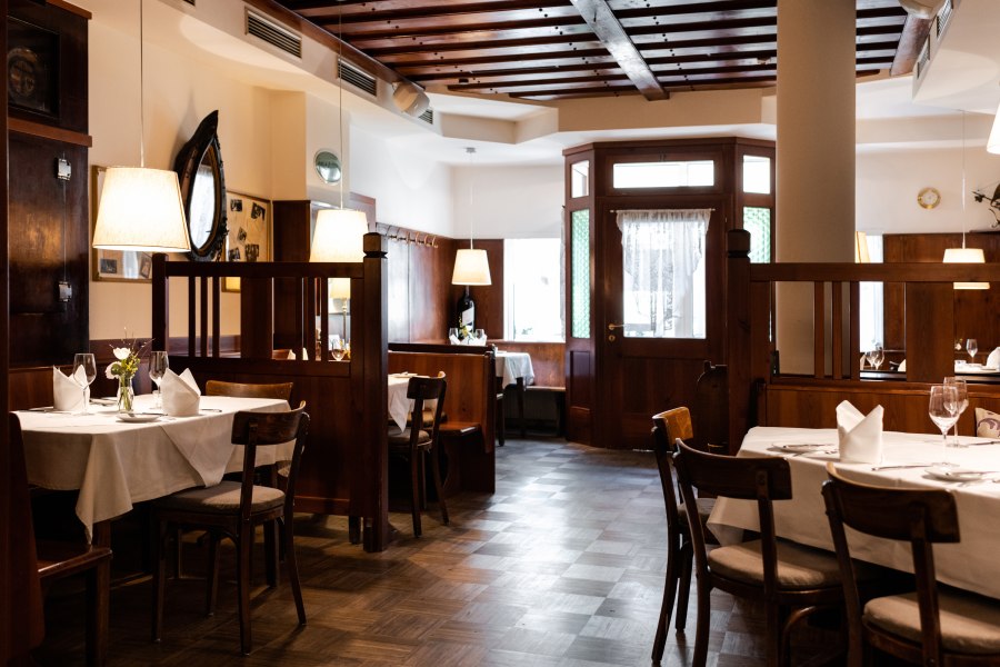 Gemütliches Restaurant mit Holzmöbeln und gedeckten Tischen.