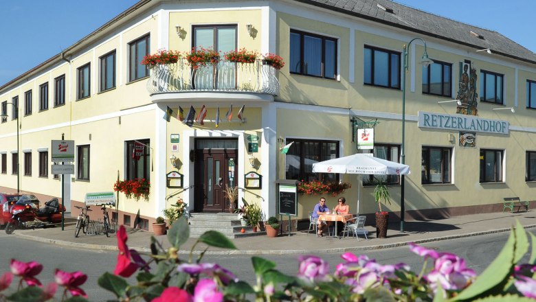 Außenansicht des Retzerlandhofs mit Terrasse und Blumen.