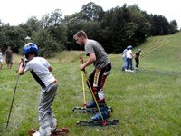 Menschen beim Grasskifahren auf einer Wiese.