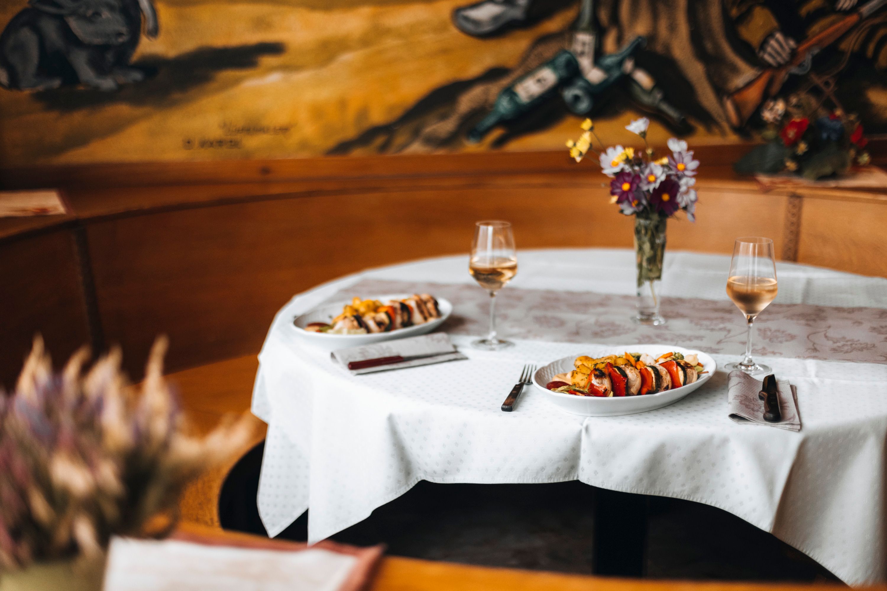 Set table in an inn with two plates and wine glasses.