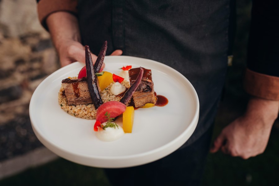 Ein Teller mit geschmortem Fleisch, Einkornrisotto, Erdäpfelschaum und Rüben-Variation.
