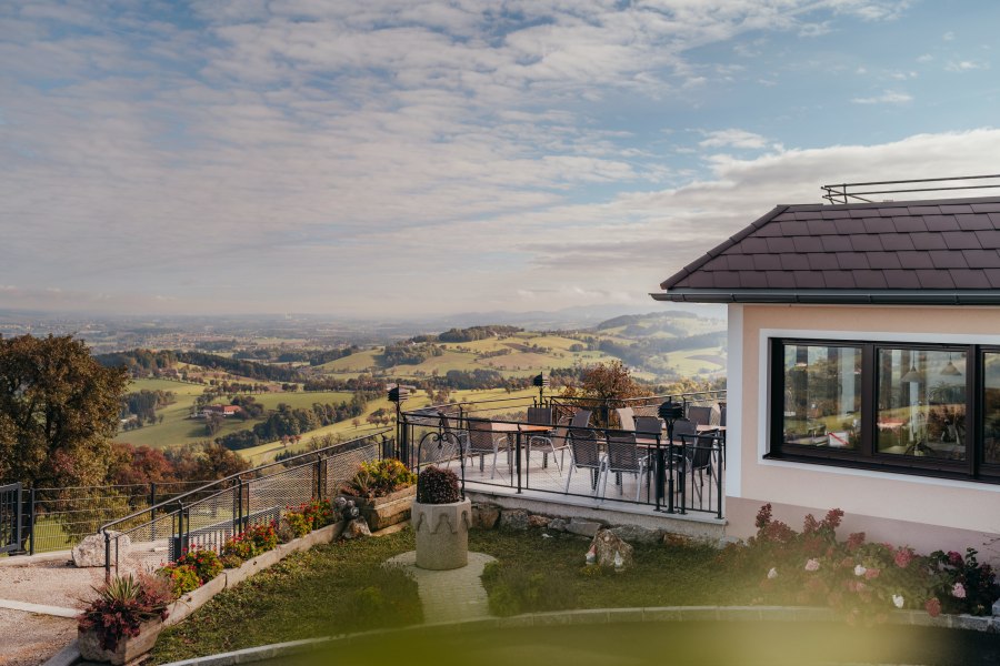 Panoramablick von einem Gasthof in St. Peter in der Au mit Terrasse und Landschaft.