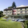 Außenansicht eines Hotels mit Garten und Poolbereich.