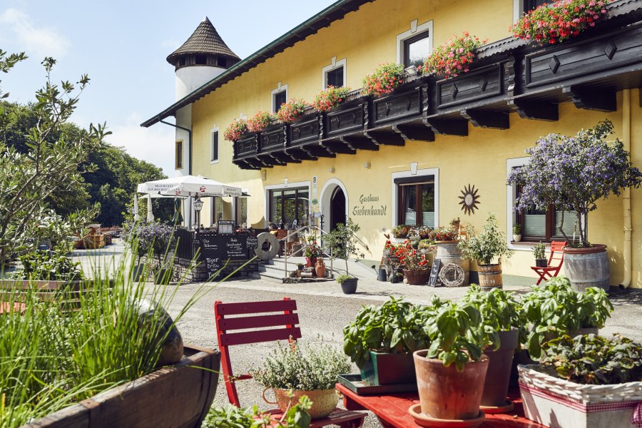 Gem&uuml;tliches Gasthaus mit Blumenschmuck und Terrasse, l&auml;ndliche Atmosph&auml;re.
