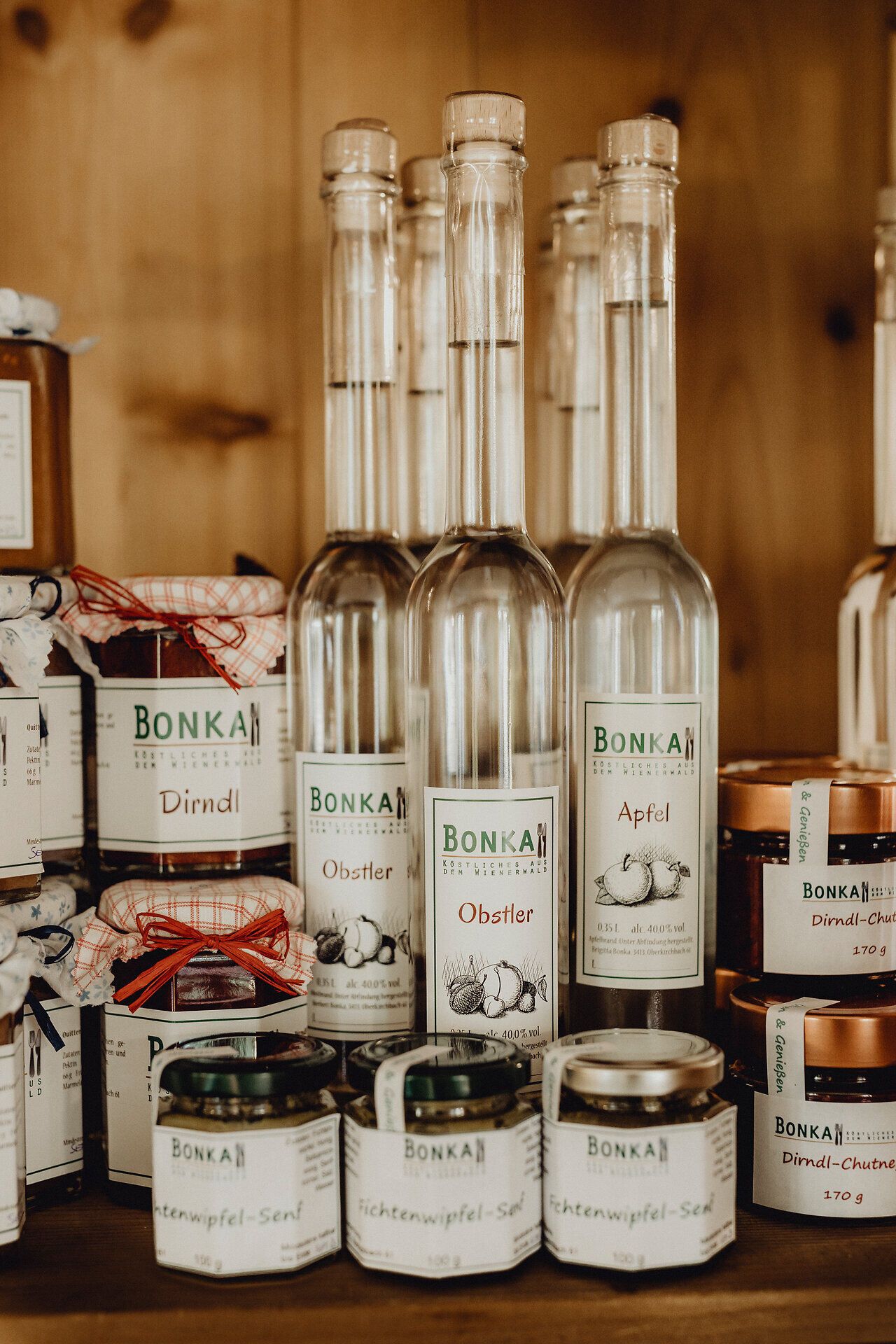 In einem einladenden Wirtshaus, umgeben von rustikalen Holzmöbeln, stehen edle Flaschen mit Obstbränden und köstlichen Marmeladen bereit. Der Duft von frisch zubereiteten Speisen und die herzliche Atmosphäre laden dazu ein, die regionalen Spezialitäten zu genießen und die Seele baumeln zu lassen.