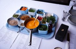 Verschiedene Zutaten und Kräuter für einen Workshop beim Branchentag der Wirtshauskultur Niederösterreich, darunter Karottencreme, frische Kräuter und Gewürze.