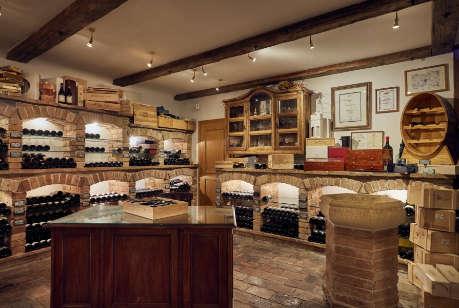 Weinkeller mit Backsteinregalen und Weinflaschen.