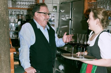 Wirt und Auszubildende Service im Gespräch hinter der Schank