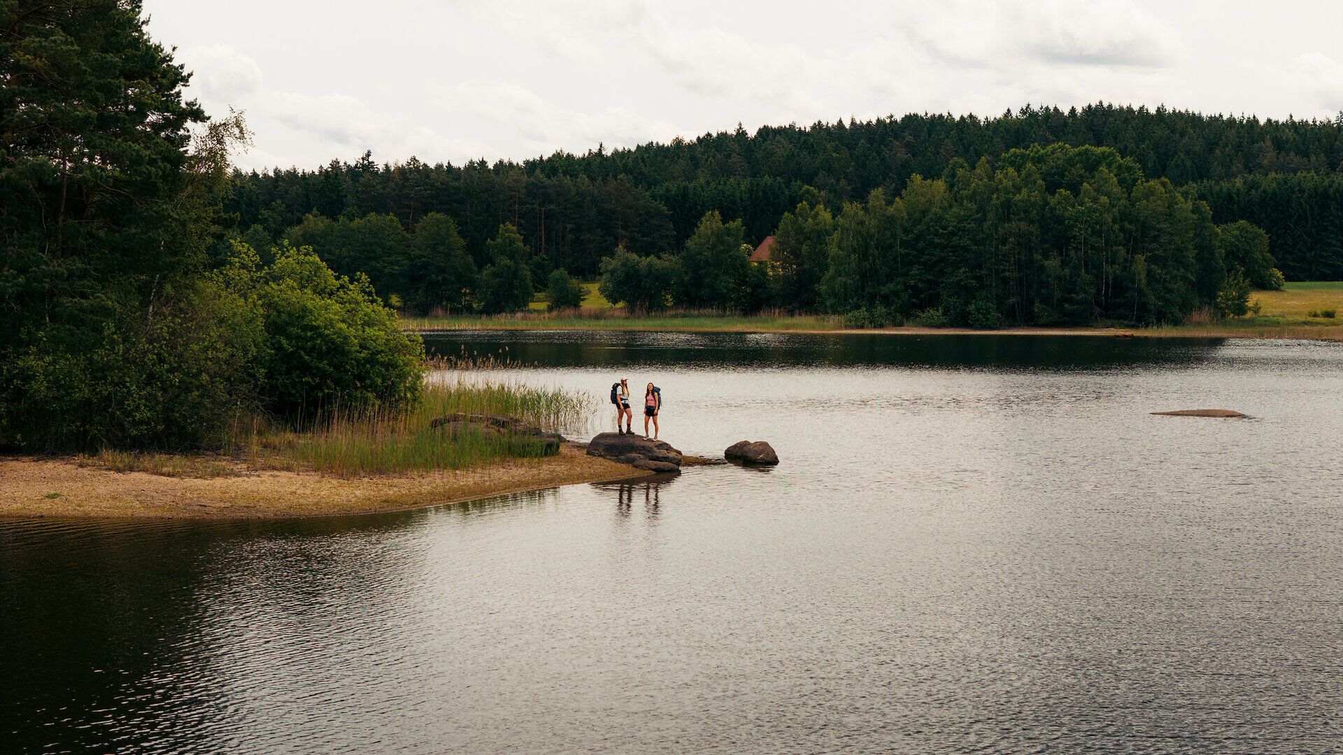 Zwei Frauen stehen am Ufer des Brandteichs und genießen die Landschaft