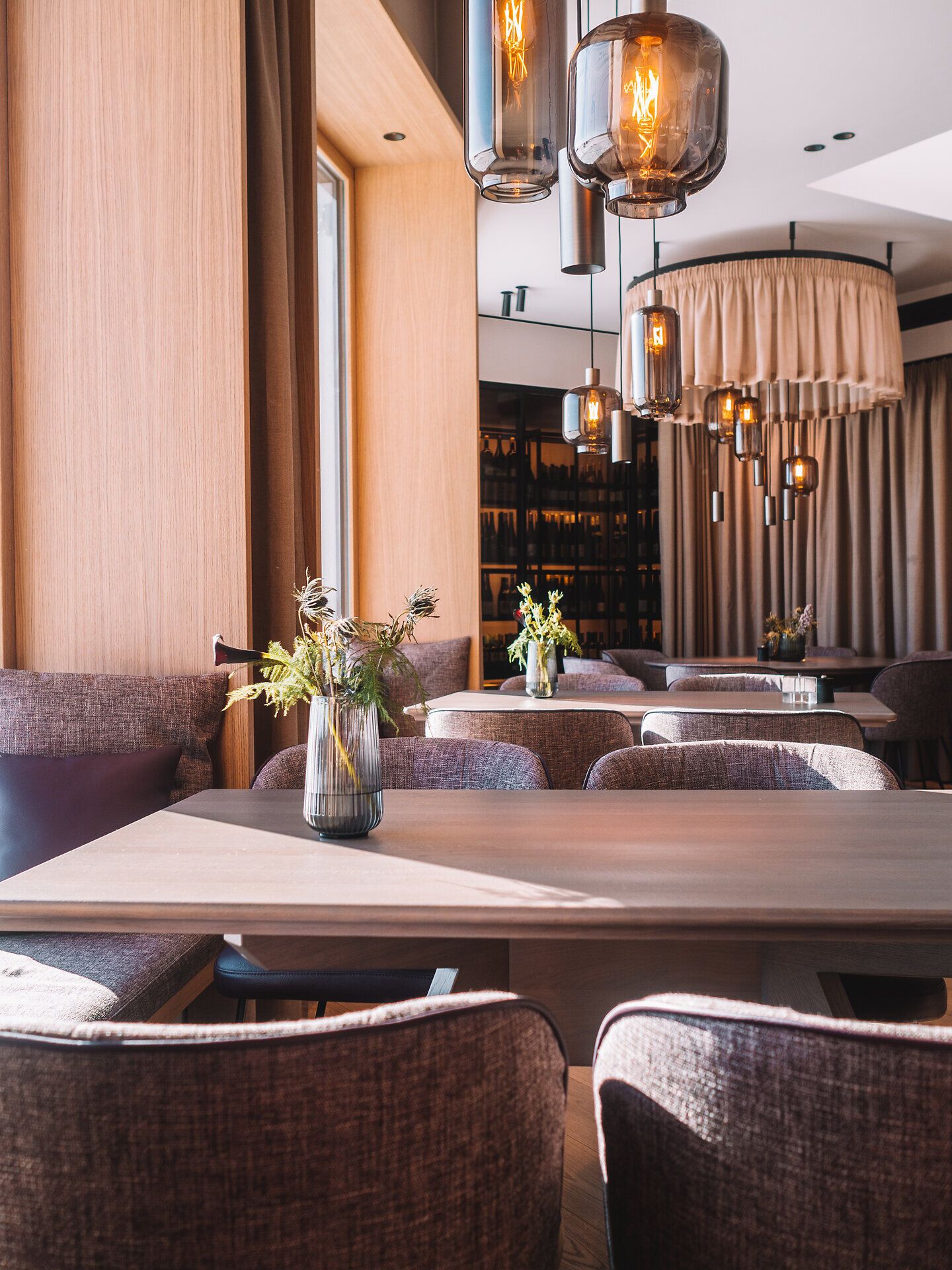 In diesem einladenden Wirtshaus strahlt eine warme Atmosphäre, die zum Verweilen einlädt. Die sanften Lichtakzente und die stilvolle Einrichtung schaffen einen perfekten Ort, um die kulinarischen Köstlichkeiten der Region zu genießen. Frische Blumen auf den Tischen verleihen dem Raum einen Hauch von Natur und Lebensfreude.