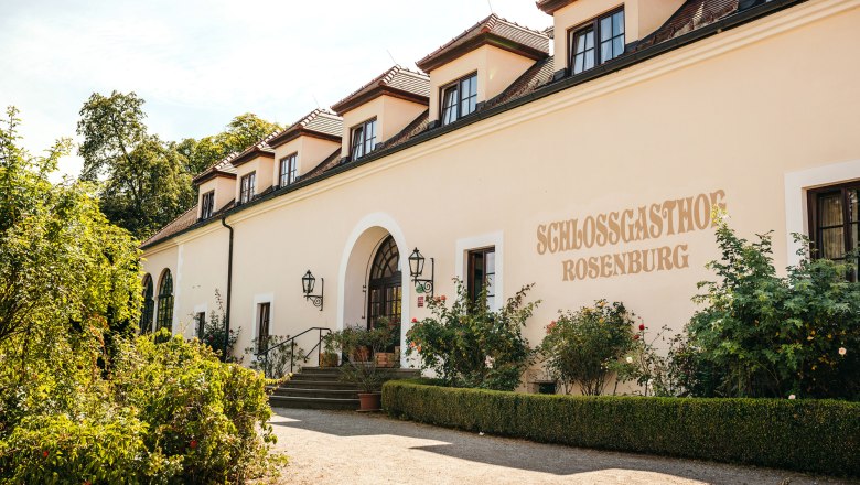 Au&szlig;enansicht des Schlossgasthofs Rosenburg mit Garten und Eingangstreppe.