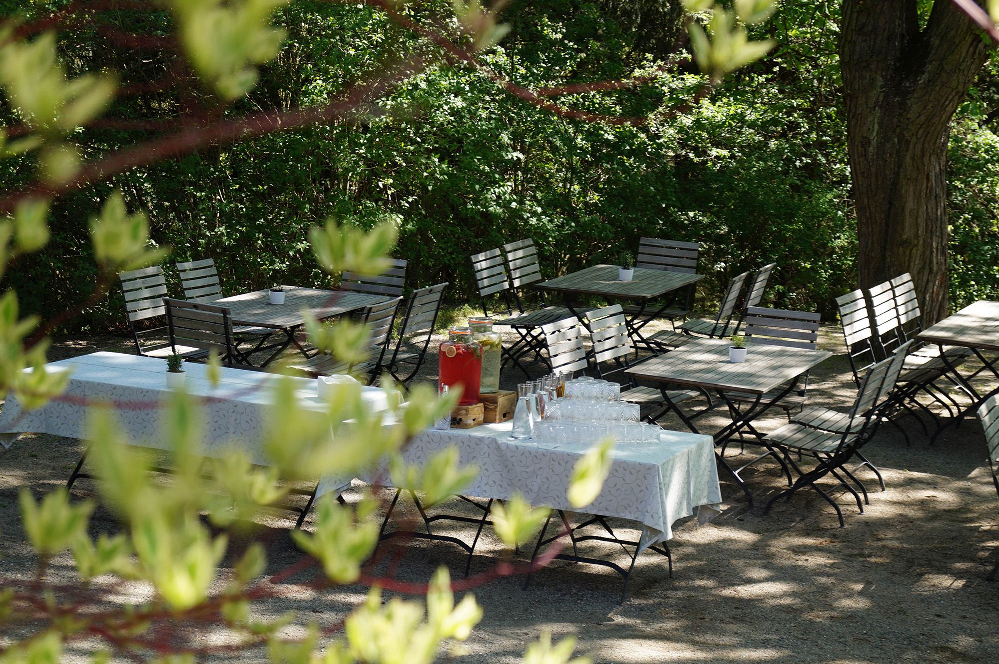 Eleganter Veranstaltungssaal mit langer, festlich gedeckter Tafel und weißen Stühlen.