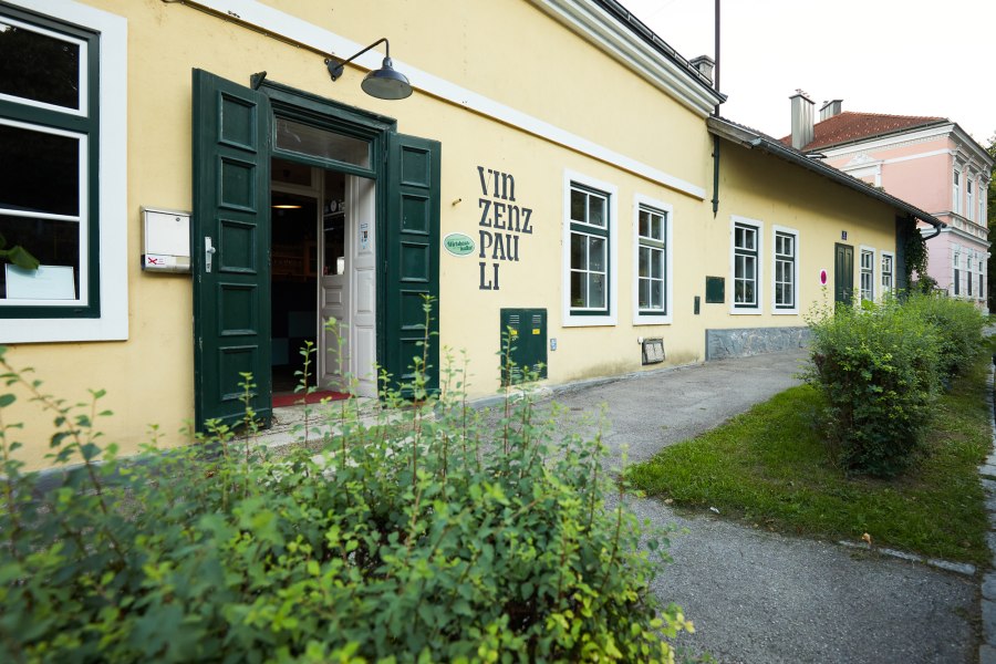 Au&szlig;enansicht eines gelben Geb&auml;udes mit der Aufschrift 'Vinzenz Pauli'.