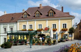 Ein traditionelles Gasthaus mit gelber Fassade und Blumendekorationen.