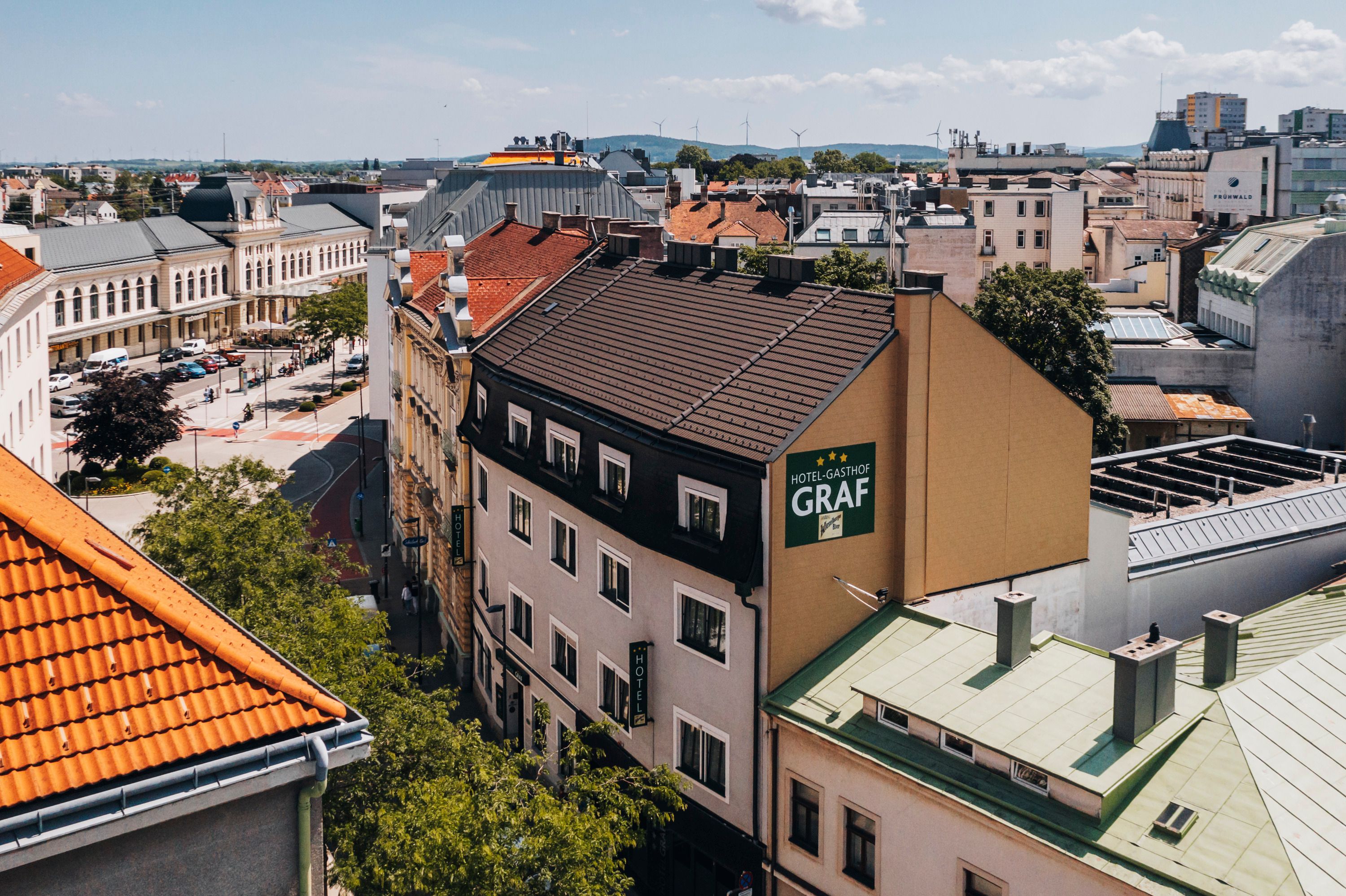 Luftaufnahme eines Hotel-Gasthofs in St. Pölten mit umliegenden Gebäuden und Straßen.