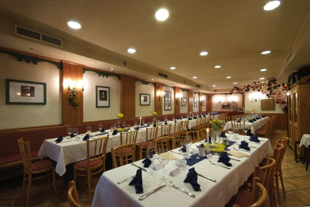 Eleganter Speisesaal mit gedeckten Tischen und blauen Servietten.