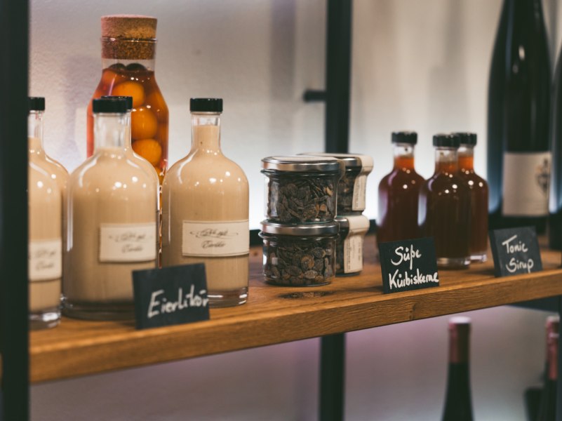 Regal mit Flaschen und Gl&auml;sern in einer Greisslerei.