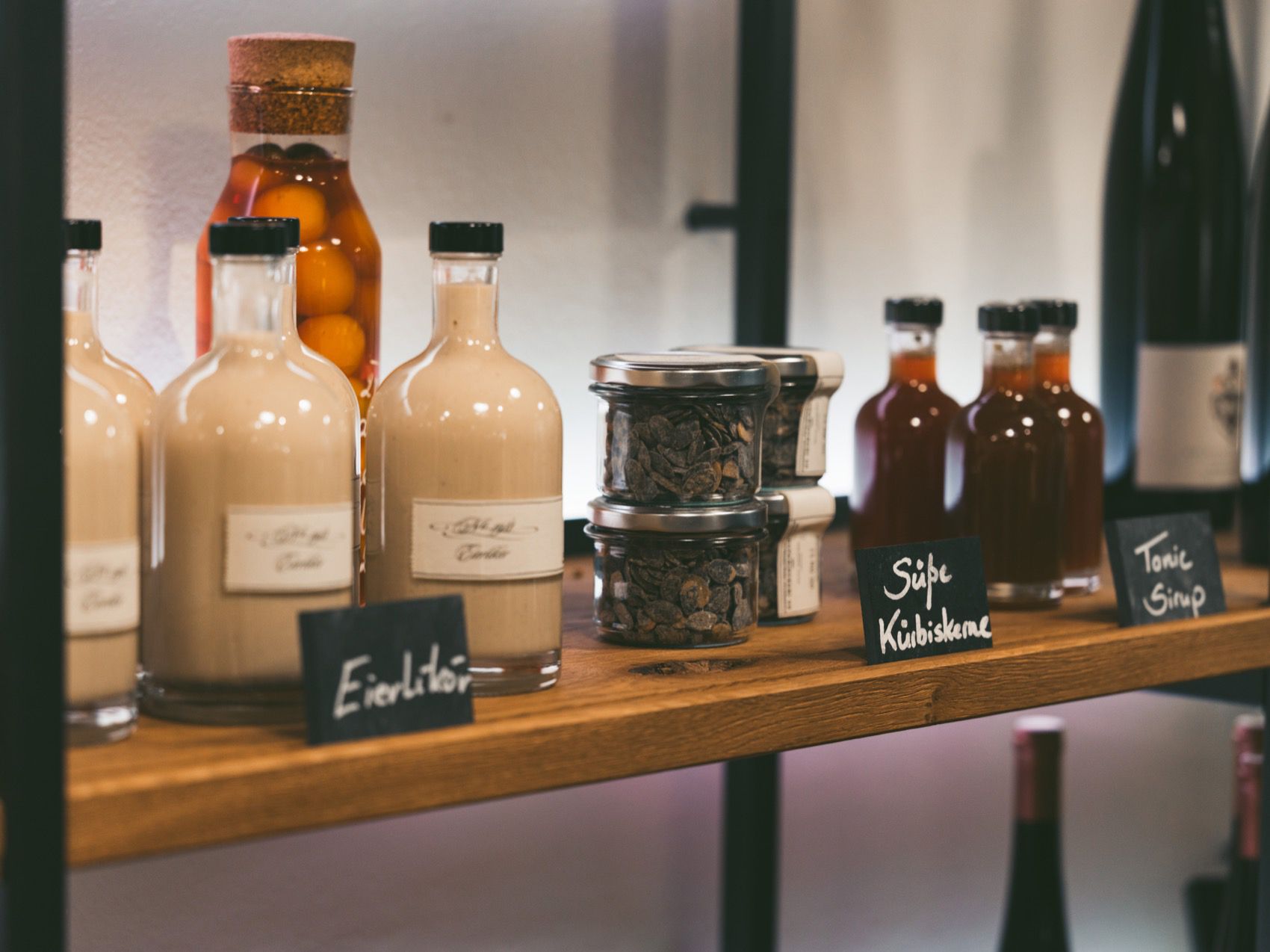 Regal mit Flaschen und Gläsern in einer Greisslerei.