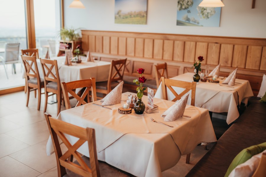 Gemütliches Restaurant mit Holzmöbeln und gedeckten Tischen.