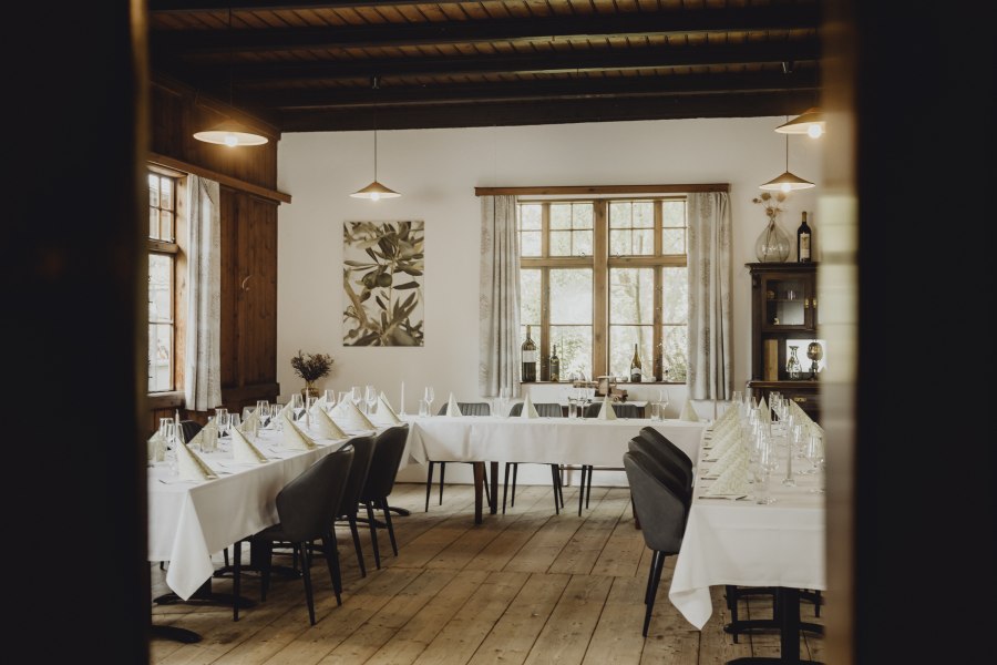 Elegantes Restaurant mit gedeckten Tischen und Holzboden.