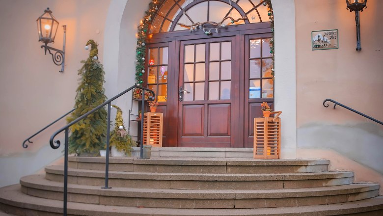 Eingang mit dekorierten Weihnachtsb&auml;umen und Lichtern.