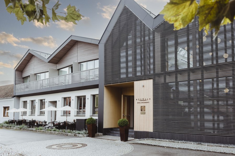 Modernes Hotelgebäude mit Terrasse und stilvoller Fassade.